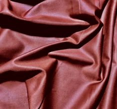 a close up view of a shiny red fabric with very thin lines on the surface