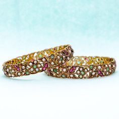 Exquisite, stylish vintage pair of silver-gilt and gem-set bangle bracelets from India. Each hinged set with beautiful emeralds, lovely rubies, and elegant seed pearls. Both bangles have hidden clasps and gold safety chains. These handcrafted bracelets are stunning.   Measurements: Approximately 6 3/4" Length Approximately 3/8" Width  Condition: Very Good Period: Circa 1900 Gold Bangles Set, Traditional Bangles, Modern Bangle, 18k Gold Bangle, Stone Bangles, Kundan Bangles, Gold Bangle Set, Resin Bangles, Gold Bridal Jewellery Sets