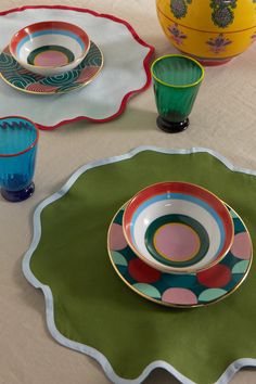 the table is set with colorful dishes and cups