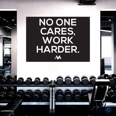 there is a sign that says no one cares, work harder on the wall behind rows of dumbs