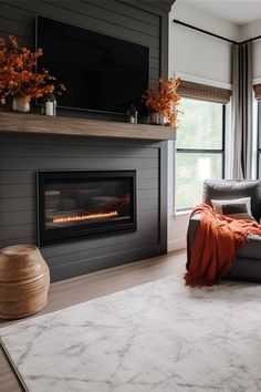 a living room with a couch, fireplace and large window overlooking the trees in the distance