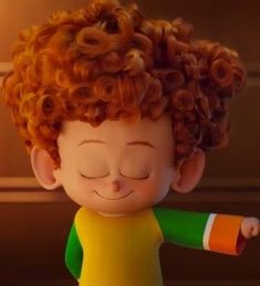 a little boy with curly red hair and green shirt