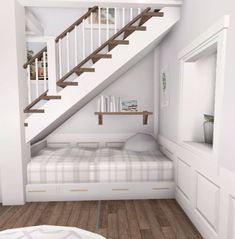 a bed sitting under a stair case in a bedroom next to a white wall and wooden floor