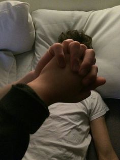 a person laying on top of a couch with their hands in the air