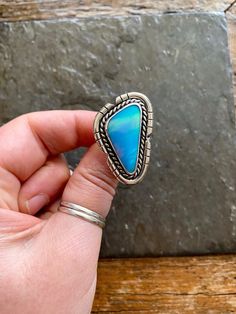 Handmade Aurora Opal and sterling silver ring.  -Ring will fit US size 9  Beautiful and unique Aurora Opal!!  Pale blueish-lavender color with amazing cotton candy pink flash! Pinks, blues, purples and greens mixed in this Opal. Cut out border design. Double, chunky style ring band.   100% Sterling silver. --------------------- Every piece will come packaged in a recycled kraft paper jewelry box. We ship worldwide. Check out our other listings! and follow us on Instagram for shop updates! Please Blue Cabochon Opal Ring In Sterling Silver, Blue Opal Open Ring In Sterling Silver, Blue Opal Cabochon Ring, Unique Blue Turquoise Ring, Artisan Blue Rings One Of A Kind, Artisan Blue Open Ring Jewelry, Artisan Blue Ring, Bohemian Blue Opal Ring In Sterling Silver, Blue Opal Ring In Sterling Silver, Bohemian Style