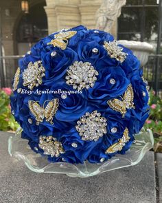 a blue bridal bouquet with gold and crystal brooches in the shape of butterflies