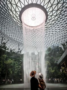 couple standing in front of the rain vortex at the jewel in Singapore Changi Airport Instagrammable Places, The Jewel