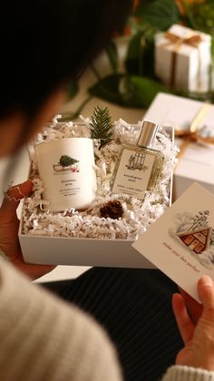 a person holding an open gift box filled with personal care products and gifts for the holiday season