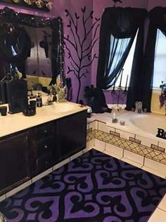 a bathroom with purple walls, black and white rugs and large mirror above the bathtub