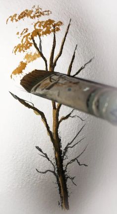 a brush painting a tree on the wall