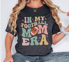 Are you a football mom? Do you love watching your son or daughter play football but hate having to worry about wardrobe malfunctions? This trendy in my football mom era is the shirt for you! It features a comfortable and stylish design that will make you feel confident and ready for game day. So why not order yours today? You won't regret it!  How To Order  - Please make sure you have looked at all sizes and color charts. - Select from the various T-Shirt sizes and colors from scroll down menus. Football Mom Gifts, Senior Football, Football Mom Shirts, Football Gift, Mom Tshirt, Mom Era, Shirt Football, Grandma Shirts, Retro Football