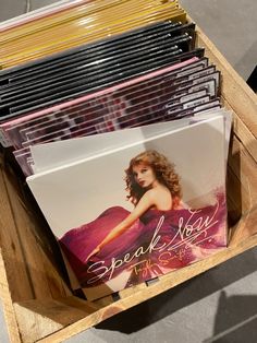 a wooden box filled with lots of cd's on top of a table next to each other