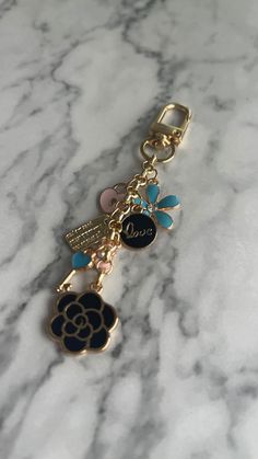 a key chain with charms on it sitting on a marble surface