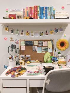 a white desk topped with lots of books next to a wall mounted book shelf filled with books