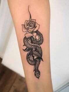 a snake with a rose tattoo on the arm is shown in black and grey ink