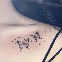 the back of a woman's shoulder with three butterflies on it and stars in the background