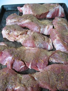 raw meat being cooked on a grill with seasoning sprinkled over it's sides