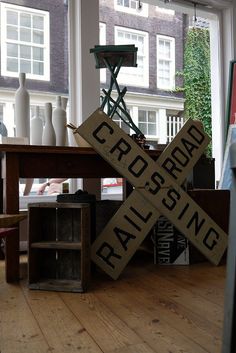 a railroad crossing sign sitting on top of a wooden table in front of a window