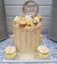 a birthday cake decorated with gold and white icing