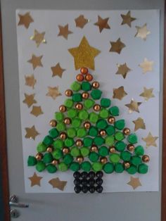 a christmas tree made out of green buttons and gold stars on a white door frame