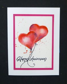 two heart shaped balloons with the words happy anniversary written on them in black and pink ink