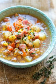 a bowl of soup with ham, potatoes and carrots