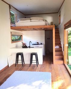 the kitchen and living room are separated by an open floor plan, with stairs leading up to the upper level