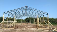 a large metal structure sitting on top of a dirt field