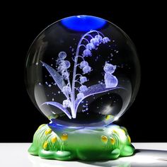 a glass snow globe with flowers in it