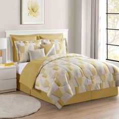 a bed with yellow and white comforters in a room