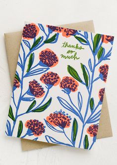 a thank card with orange and blue flowers on it, sitting next to a brown envelope