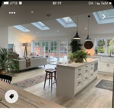 a large open kitchen and living room with skylights