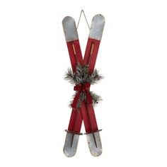 two red skis are hanging from a string with pine cones and bows on them