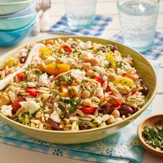 a bowl filled with pasta and vegetables on top of a table