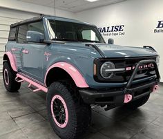 a blue and pink truck parked in a garage