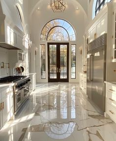 a large kitchen with white cabinets and marble flooring is pictured in this image from the front door