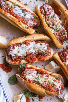 several hot dogs covered in marinara sauce and cheese on top of breadsticks