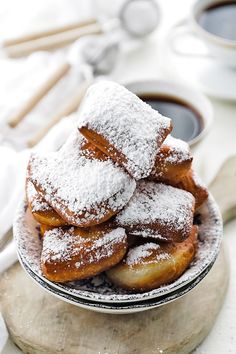 powdered sugar covered donuts on a plate