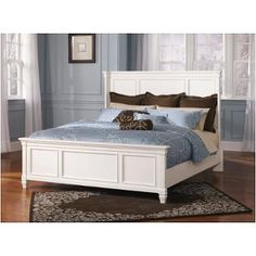 a white bed sitting in a bedroom on top of a hard wood floor