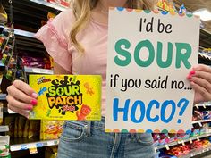 a woman holding a sign that says i'd be sour if you said no hoco?