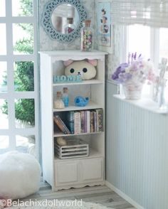 a white book shelf with books on it in a room next to a door and window