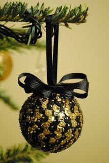 a black and gold ornament hanging from a christmas tree