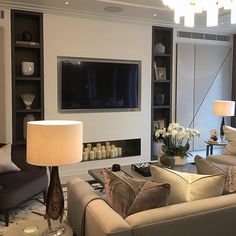 a living room filled with furniture and a flat screen tv mounted on the wall above it