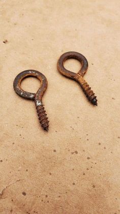 two rusty screwdrivers sitting on top of a piece of cardboard