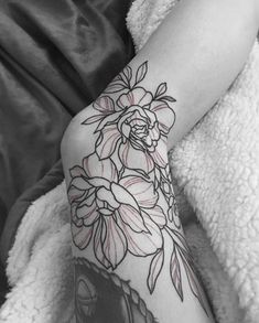 black and white photo of a woman's arm with flowers tattooed on the arm