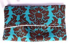 a blue and brown flowered purse on a white surface with the bottom flap open