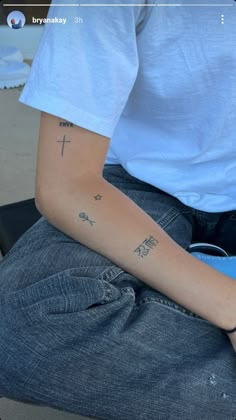 a person with a cross tattoo on their arm