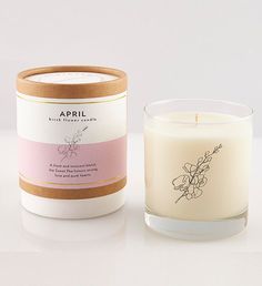 an open candle sitting next to a white container with a pink flower on the inside