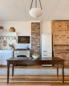 an old fashioned kitchen with white appliances and wood flooring is pictured in this image