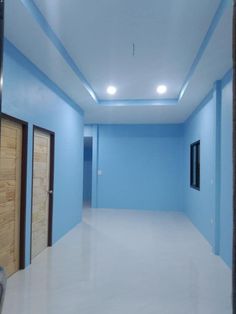 an empty room with blue walls and white floors